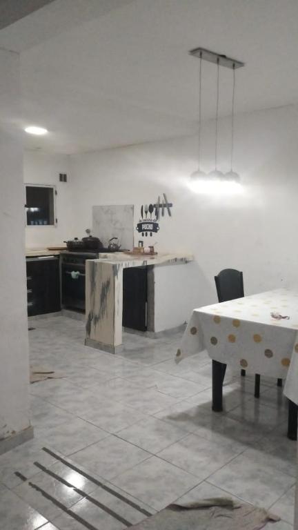a living room with a table and a kitchen at La casa naranja de Amaia in Sierra Grande