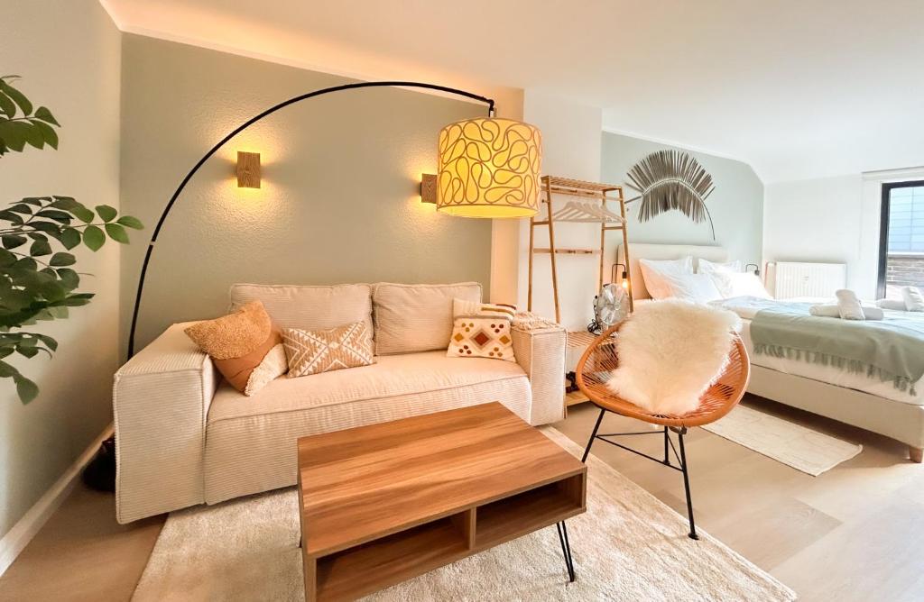 a living room with a couch and a bed at III Kingsizebetten l Balkon l Nähe Dom und Universität in Aachen