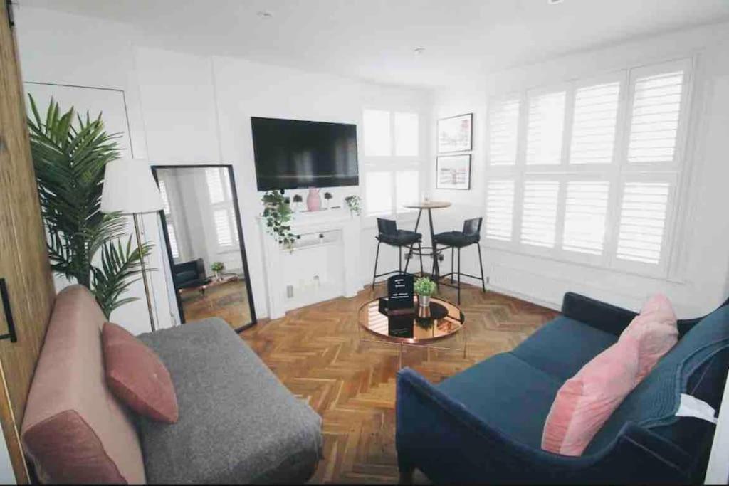 a living room with a couch and a table at Cute & Quiet Apartment in the Heart of Hampstead in London