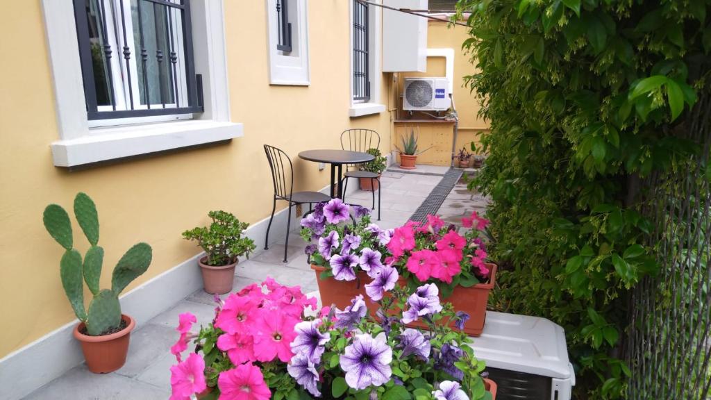 a patio with flowers and a table and chairs at Francarooms in Florence