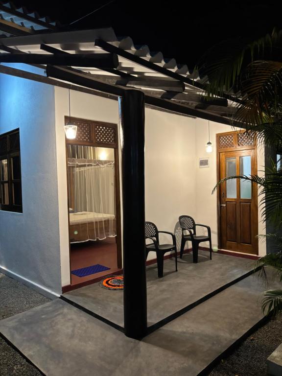 a view of a patio with chairs and a room at Ima House in Hiriketiya