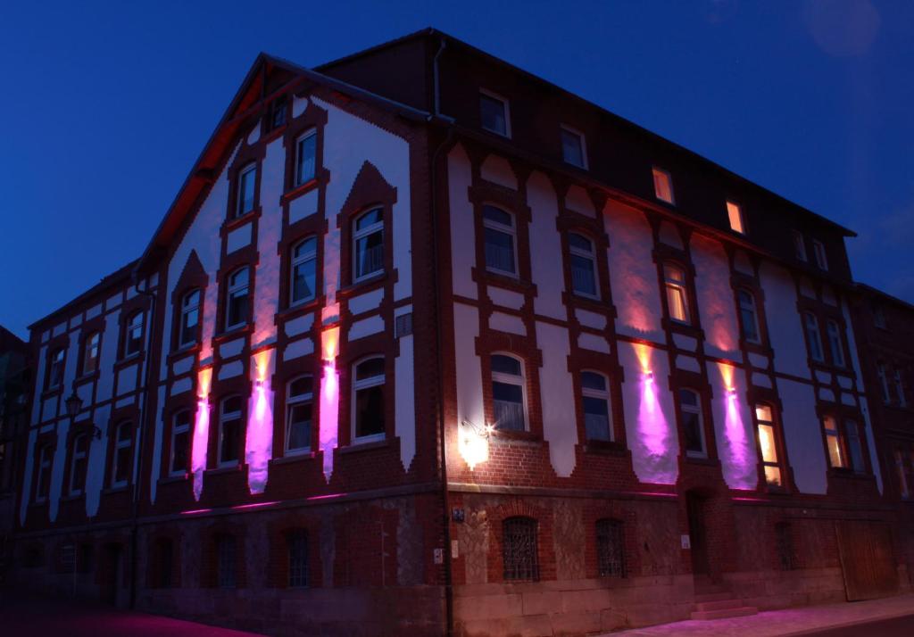 un edificio con luces rosas en el lateral. en Pension zur Sonne 24/7, en Poppenhausen