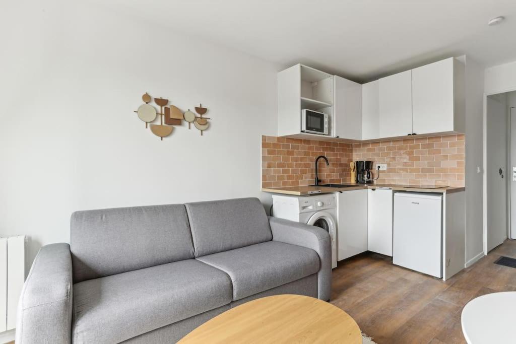 un salon avec un canapé et une cuisine dans l'établissement Nice studio close to Paris, à Maisons-Alfort