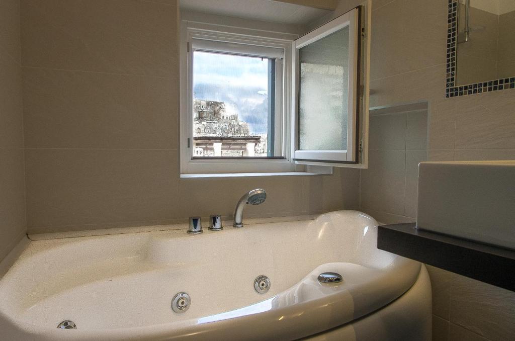 W łazience z oknem znajduje się wanna. w obiekcie La Scala Suite w mieście Matera
