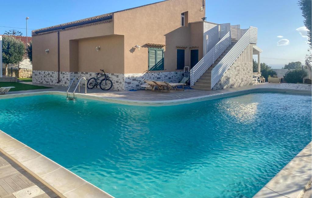 ein Swimmingpool vor einem Haus in der Unterkunft Cozy Home In Marina Di Ragusa in Marina di Ragusa