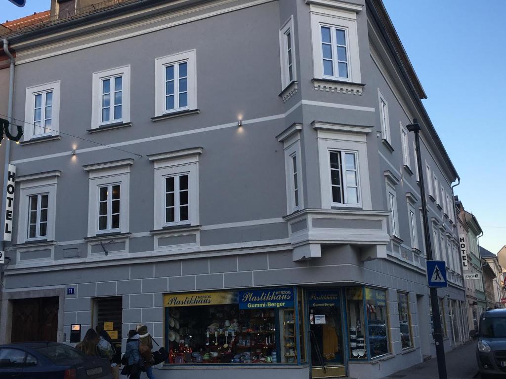 um grande edifício branco na esquina de uma rua em Hotel SINOS em Klagenfurt