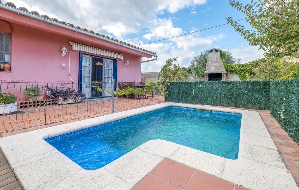 a swimming pool in front of a pink house at Awesome Home In Sant Miquel De Fluvià in San Miguel de Fluviá