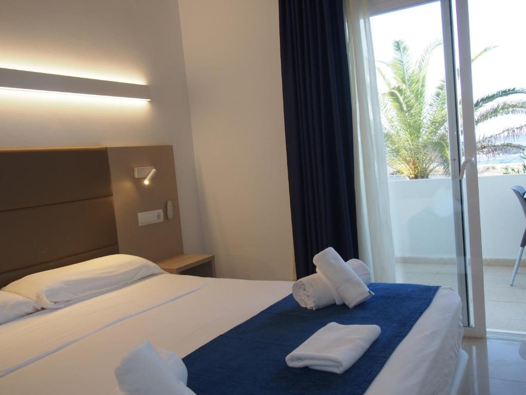 a hotel room with a bed with towels on it at Hotel Roca Bella in Es Pujols