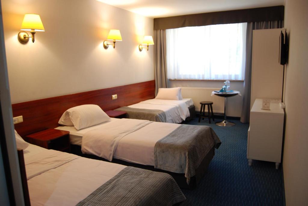 Postel nebo postele na pokoji v ubytování Amigo Hotel