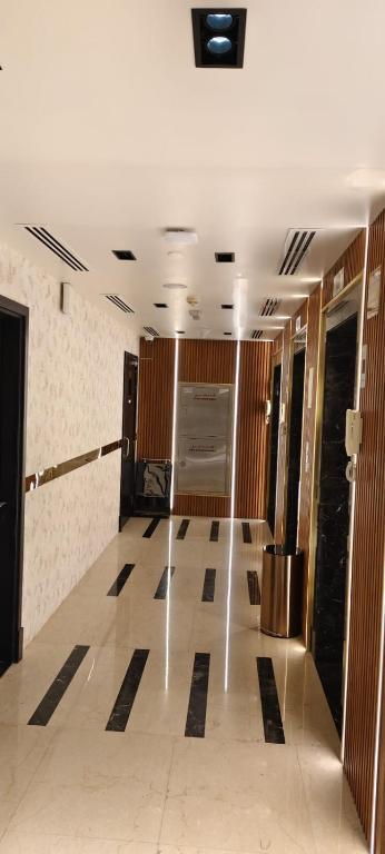 a room with a hallway with black and white tile floors at Paragon Hotel Apartments in Abu Dhabi