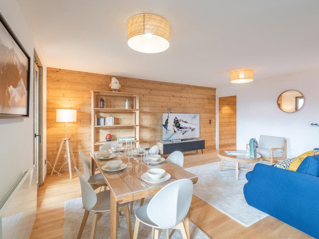 un salon avec une table et un canapé bleu dans l'établissement Appartement neuf 65m² proche centre-ville - 400m des pistes, Wi-Fi - FR-1-645-72, à Huez