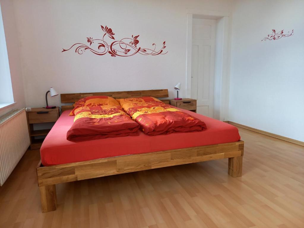 a bedroom with a bed with red sheets and a red blanket at Ulfershausen in Wangerland