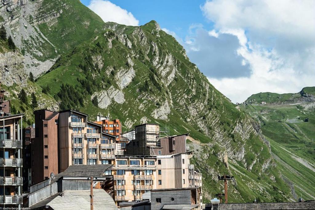 un groupe de bâtiments devant une montagne dans l'établissement Résidence Les Alpages - maeva Home - Appartement 2 pièces 4 personnes - Sélection MAE-0171, à Avoriaz