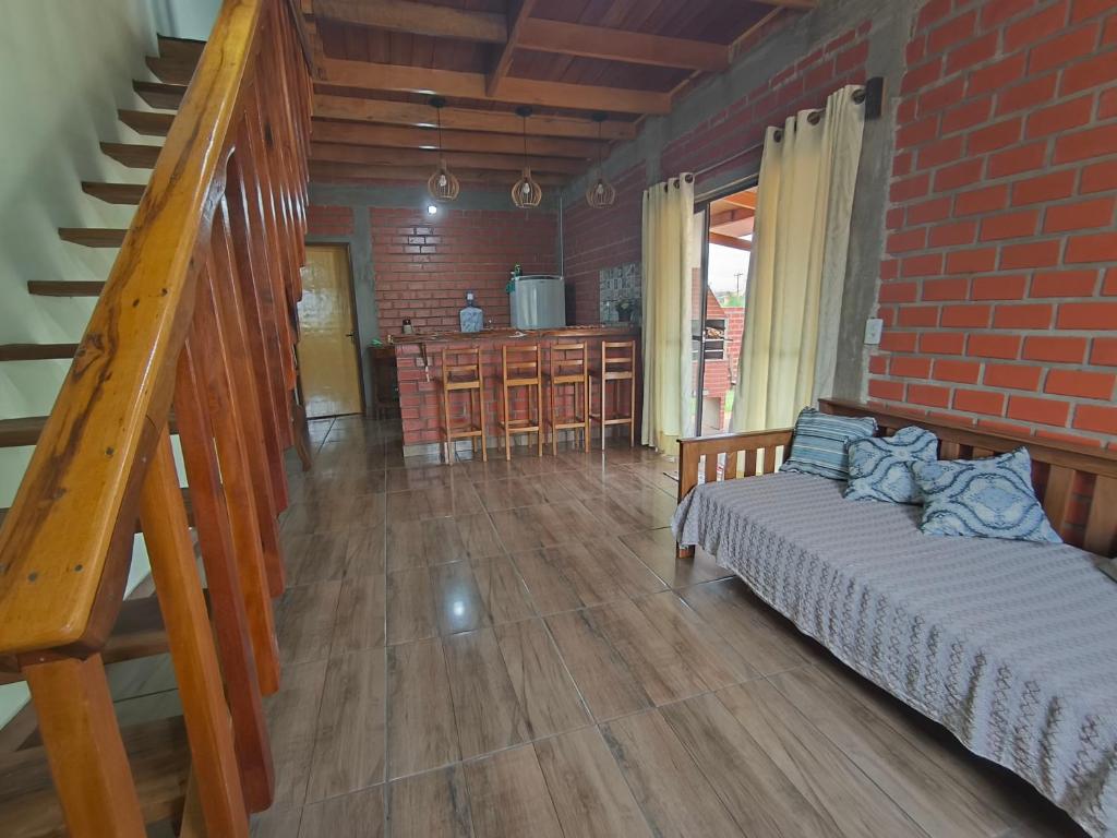 a living room with a couch and a brick wall at Pousada Recanto Sobradinho in Bonito