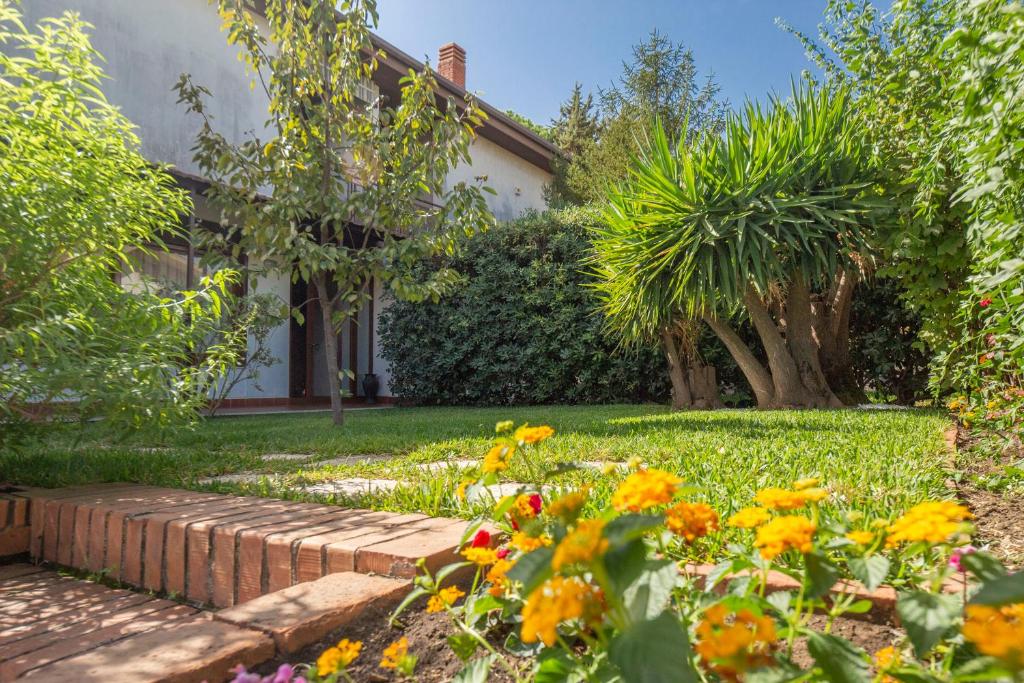a garden with flowers in front of a house at Elegante Villa con Giardino tra Catania ed Etna in Tremestieri Etneo