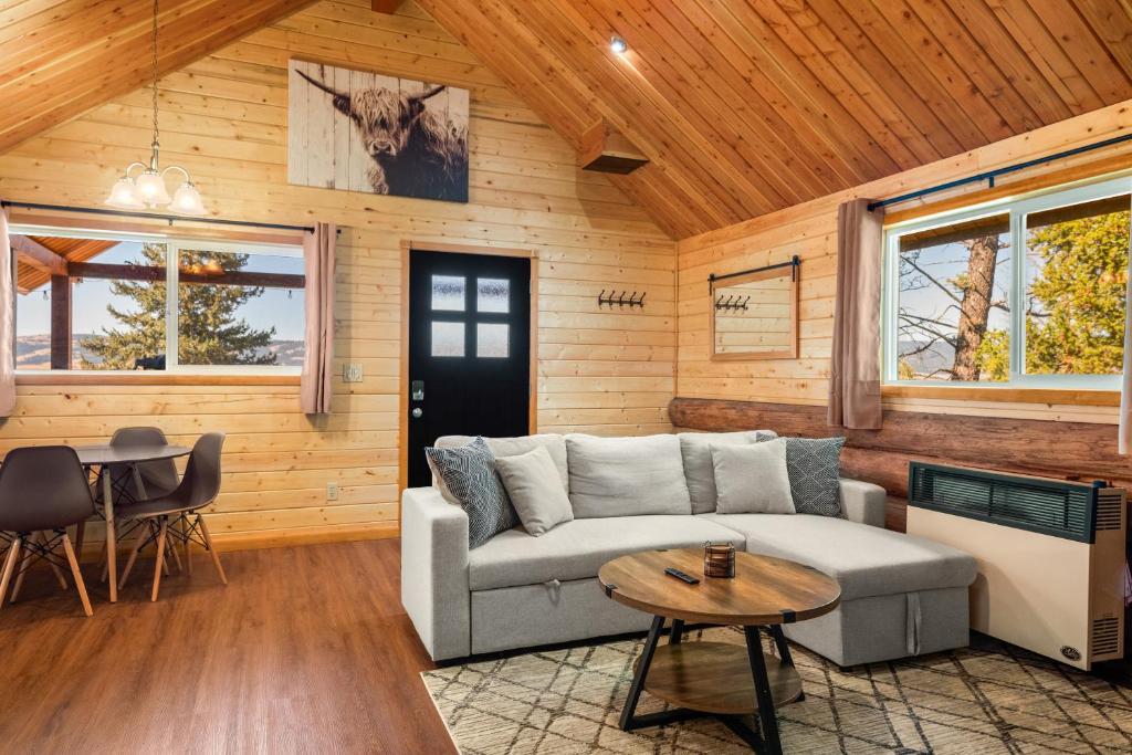 una sala de estar con un sofá y una mesa en Adventure Cabin, Sapphire Mining, Walk To Downtown, en Philipsburg