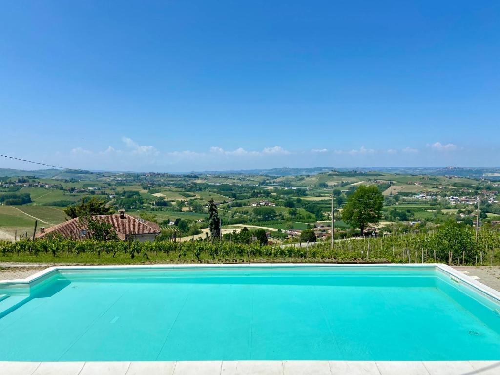 - une piscine bleue avec vue sur la campagne dans l'établissement Villa il Gelso, à Castagnole Lanze