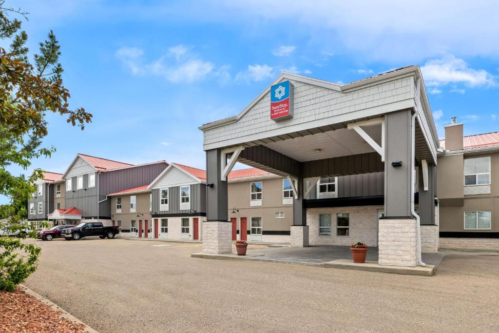 een gebouw met een parkeerplaats ervoor bij SureStay Plus Hotel by Best Western Drumheller in Drumheller