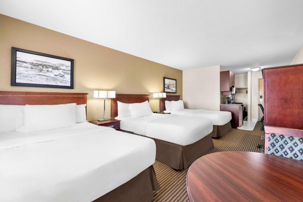Een bed of bedden in een kamer bij SureStay Plus Hotel by Best Western Drumheller