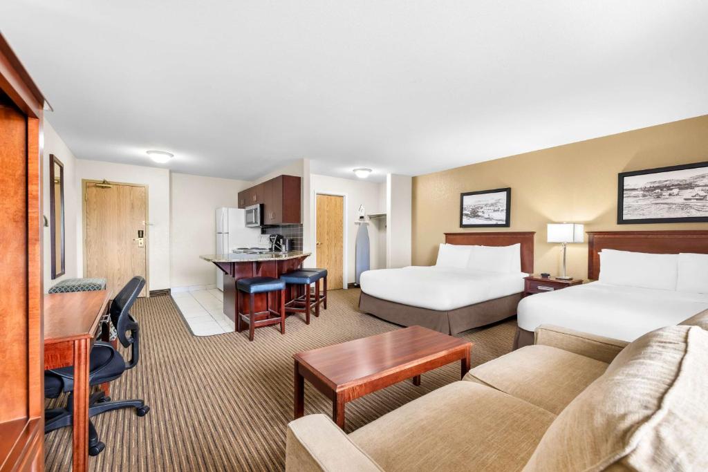 een hotelkamer met 2 bedden en een bank bij SureStay Plus Hotel by Best Western Drumheller in Drumheller