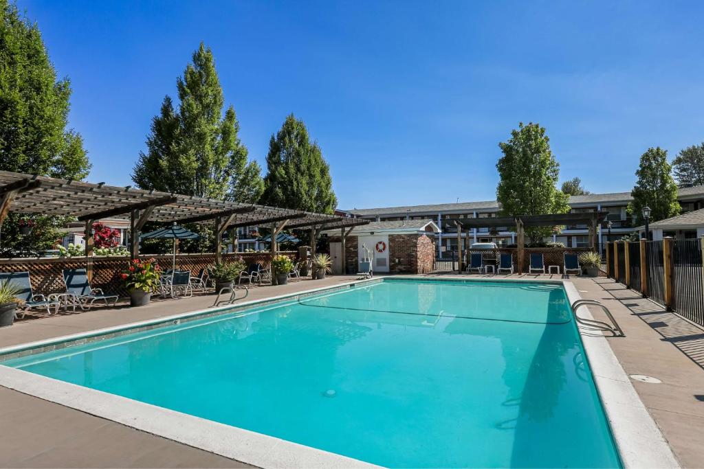 a swimming pool at a resort with tables and chairs at Best Western Horizon Inn in Medford