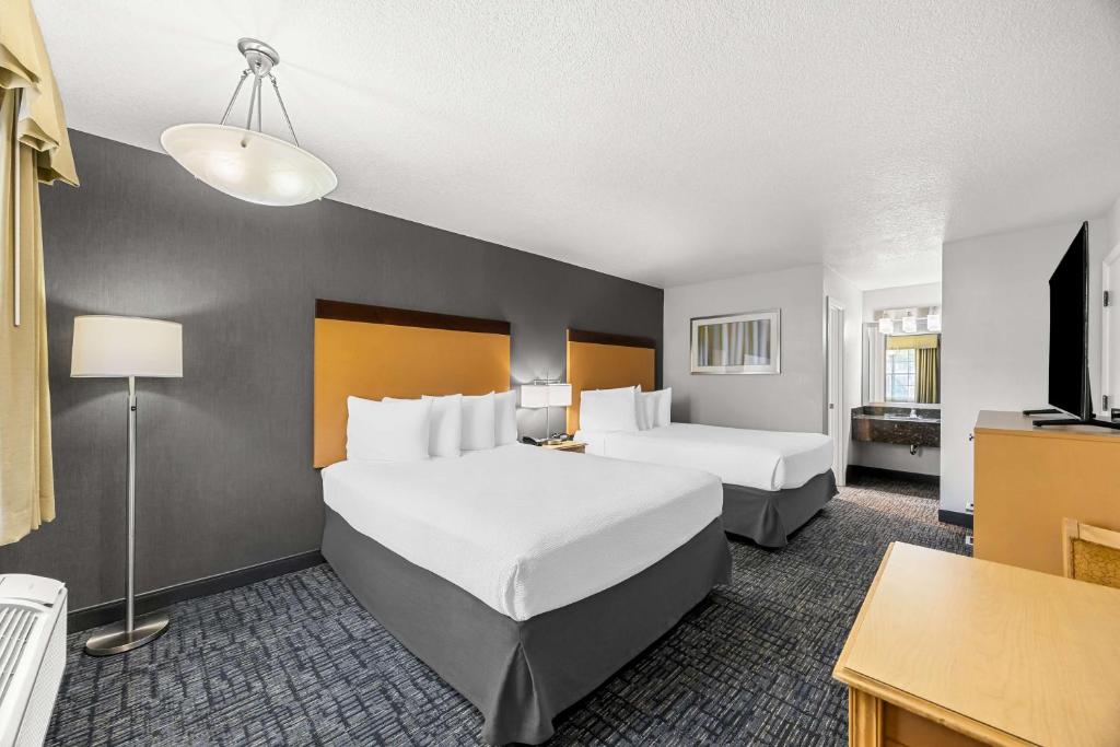 a hotel room with two beds and a desk at Best Western Horizon Inn in Medford