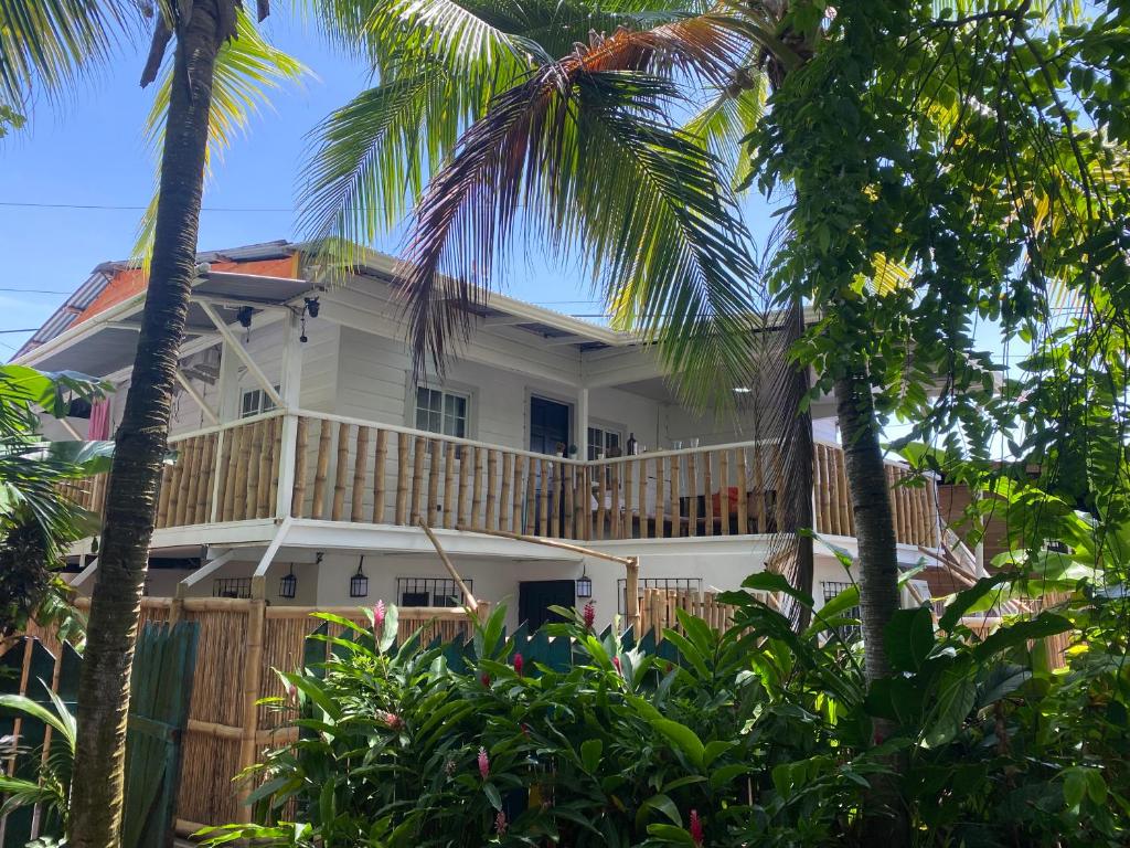 une maison avec une terrasse enveloppante et des palmiers dans l'établissement La Villa Elena, à Carenero