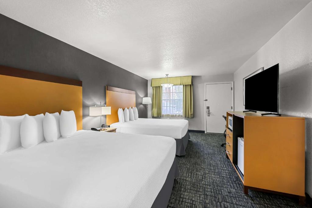 a hotel room with two beds and a flat screen tv at Best Western Horizon Inn in Medford