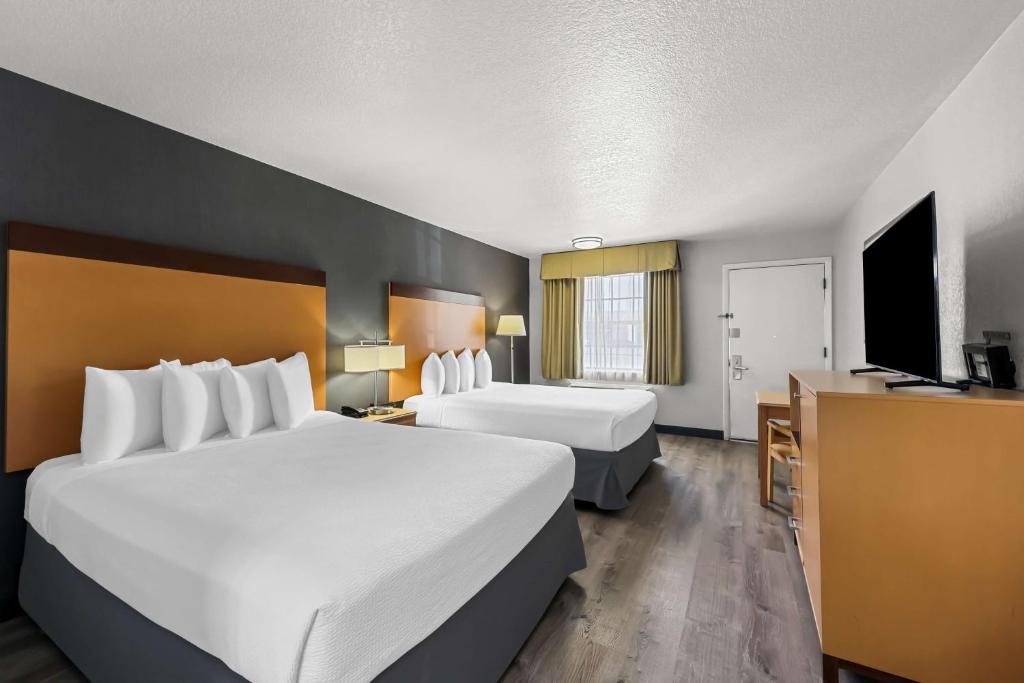 a hotel room with two beds and a desk at Best Western Horizon Inn in Medford