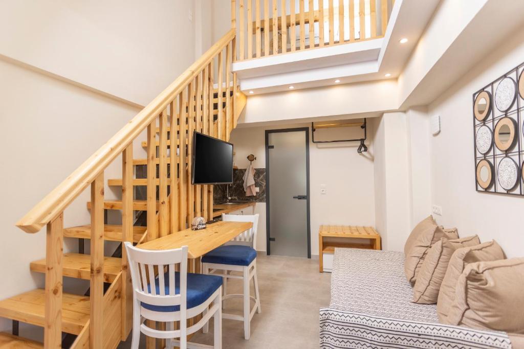 een woonkamer met een houten tafel en een trap bij Ionas Apartments 4 in Nea Skioni