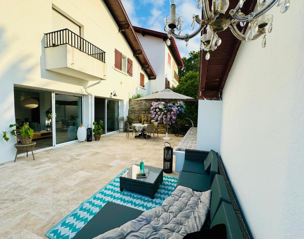 une terrasse d'une maison avec un canapé et une table dans l'établissement Argi Alde - côté lumière, à Arcangues