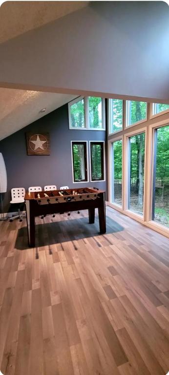 a pool table in a room with windows at Vdara Pocono Home in Tobyhanna