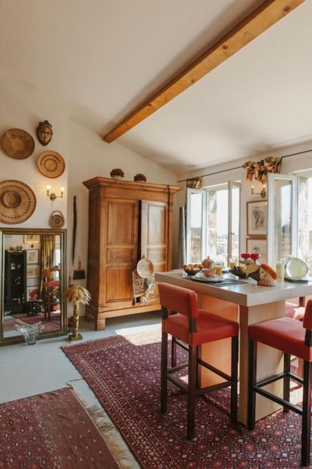 une cuisine avec une table et des chaises dans une pièce dans l'établissement Le Nid Exotique - vue sur les toits du centre-ville, à Montpellier