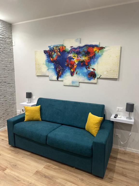 a living room with a blue couch and a painting at Fix You Apartment Fco 2 in Fiumicino