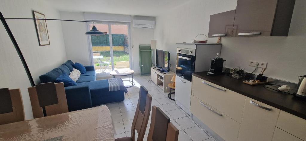 a kitchen and living room with a blue couch at Appartement, 1 chambre, jardin privatif in Venelles