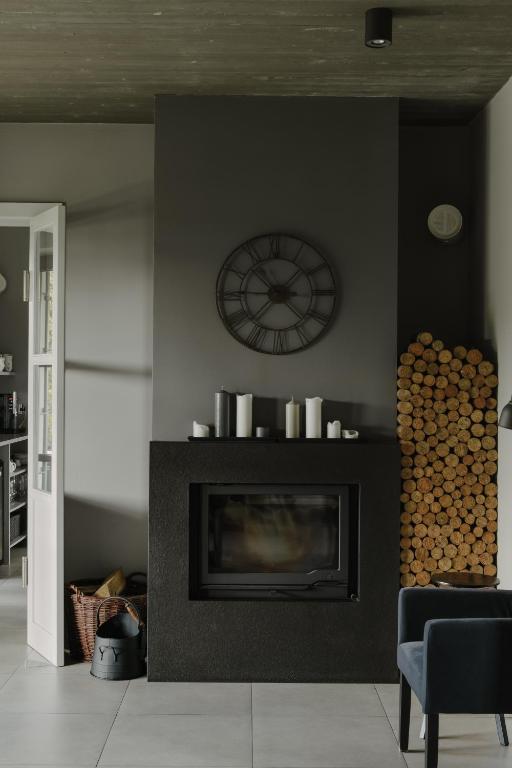 a living room with a fireplace and a clock on the wall at Villa Antiqua in Racibórz