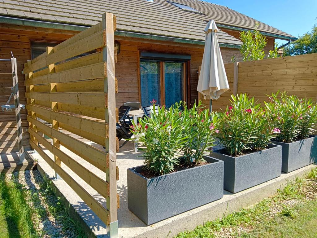 Une rangée de planteurs avec un parapluie à côté d'une maison dans l'établissement Chalet 2 chambres en Savoie pour 1 à 4 personnes, à Gerbaix