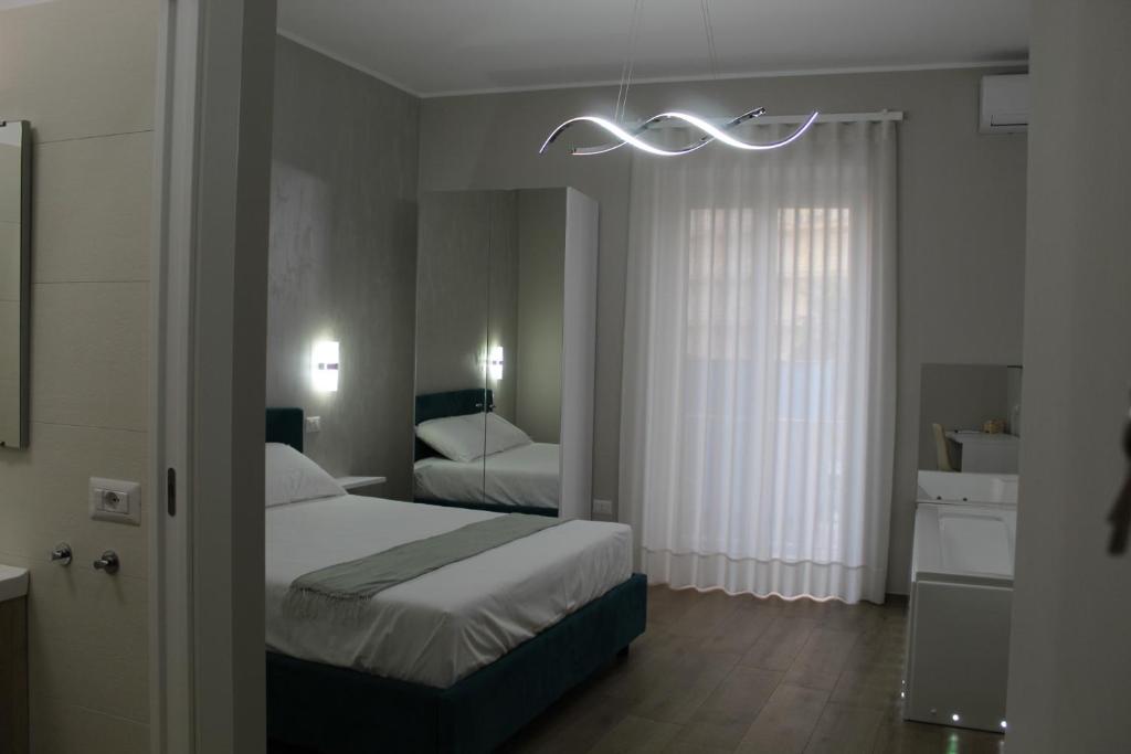 a bedroom with a bed and a chandelier at Lory luxury B&B in Licata