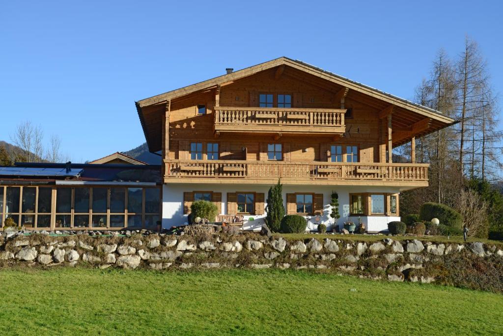 una gran casa de madera con una pared de piedra en Haus Panorama, en Reit im Winkl