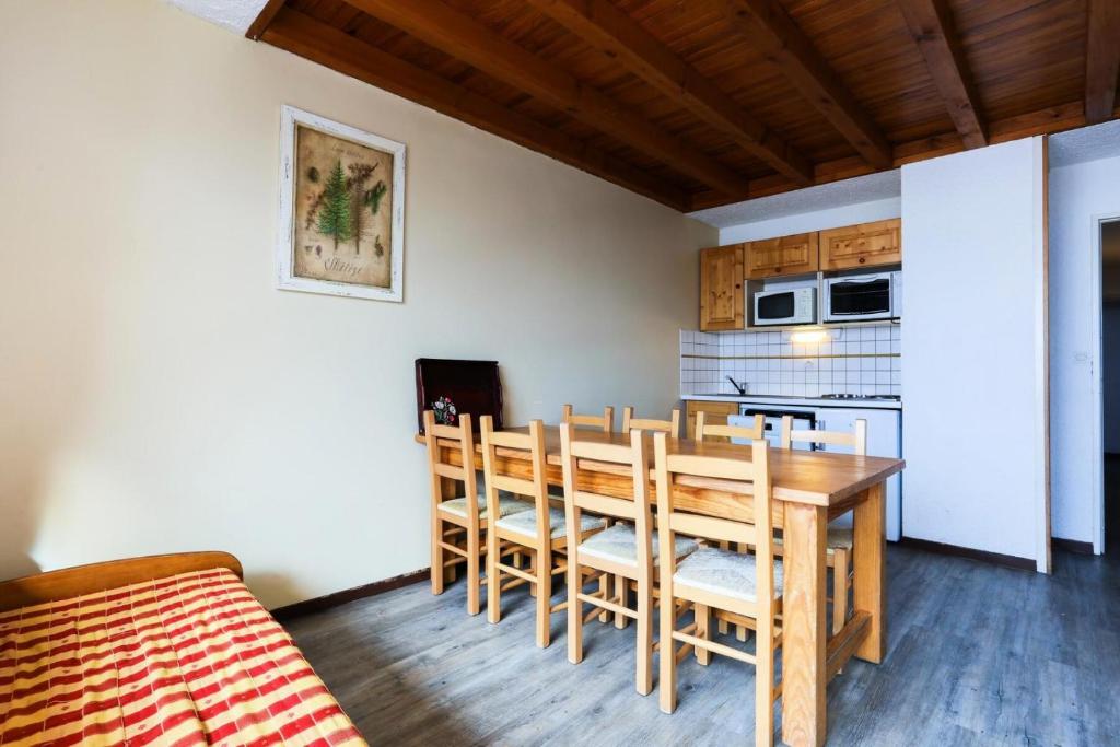 une cuisine et une salle à manger avec une table et des chaises dans l'établissement Résidence Meijotel - Appartement résidence Meijotel MAE-9761, à Vénosc