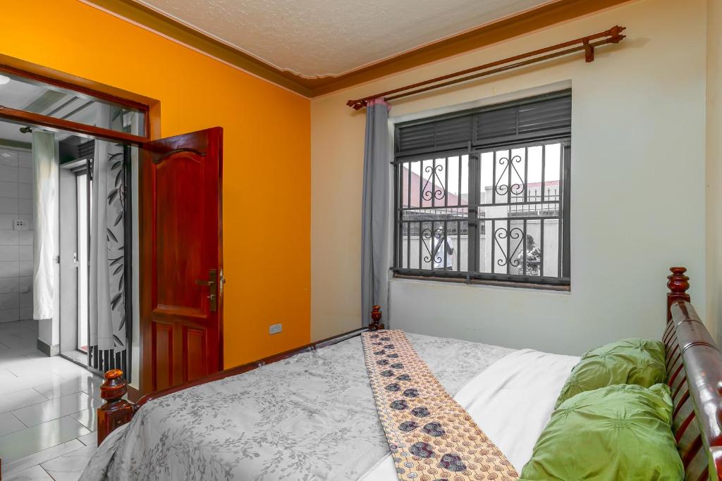 a bedroom with a bed and a window at Rendy partment- KAWUKU in Kisubi