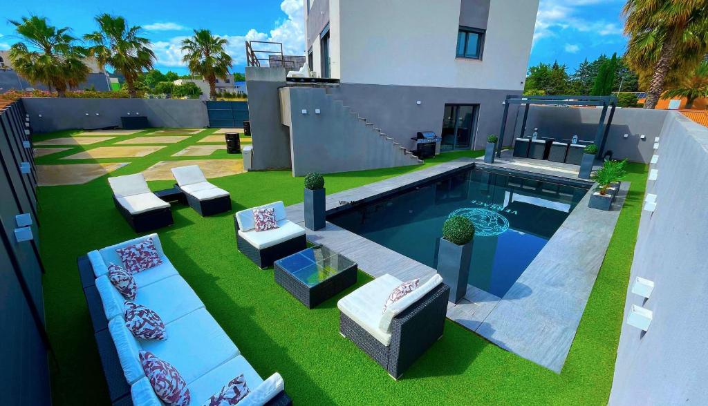 une cour arrière avec une piscine et une maison dans l'établissement Villa Medusa, du confort à proximité des plages et de Montpellier, à Vic-la-Gardiole