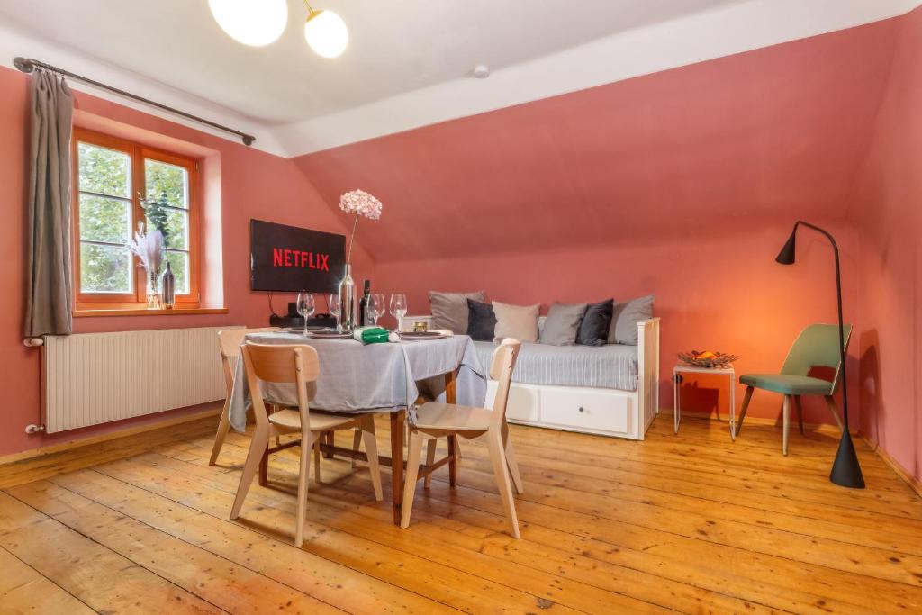 a dining room with a table and a bed at City-Loft in Villa 100und10 - Charmantes Dachstudio beim Lendkanal in Klagenfurt