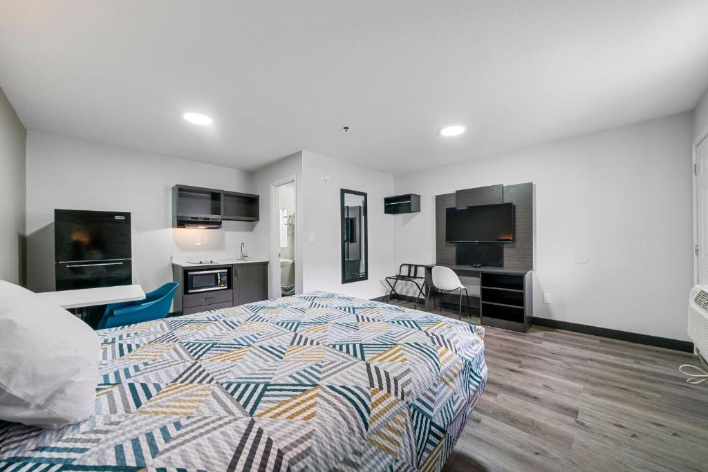 Una habitación de hotel con una cama y una cocina. en Southern Suites Cartersville, en Cartersville
