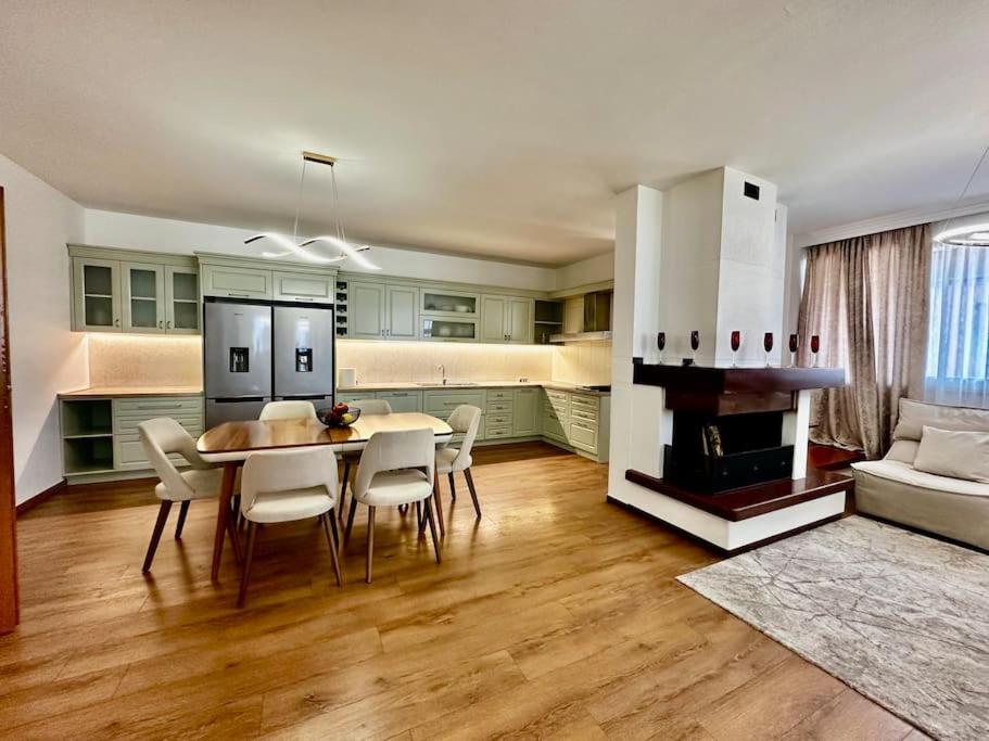 une cuisine et une salle à manger avec une table et des chaises dans l'établissement 8th Floor Luxury Apartment Tirana 2, à Selitë e Vogël