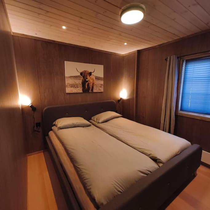 a bedroom with a bed with a picture of a cow at OlaHytta - Cozy cabin close to kvitfjell in Tromsnes