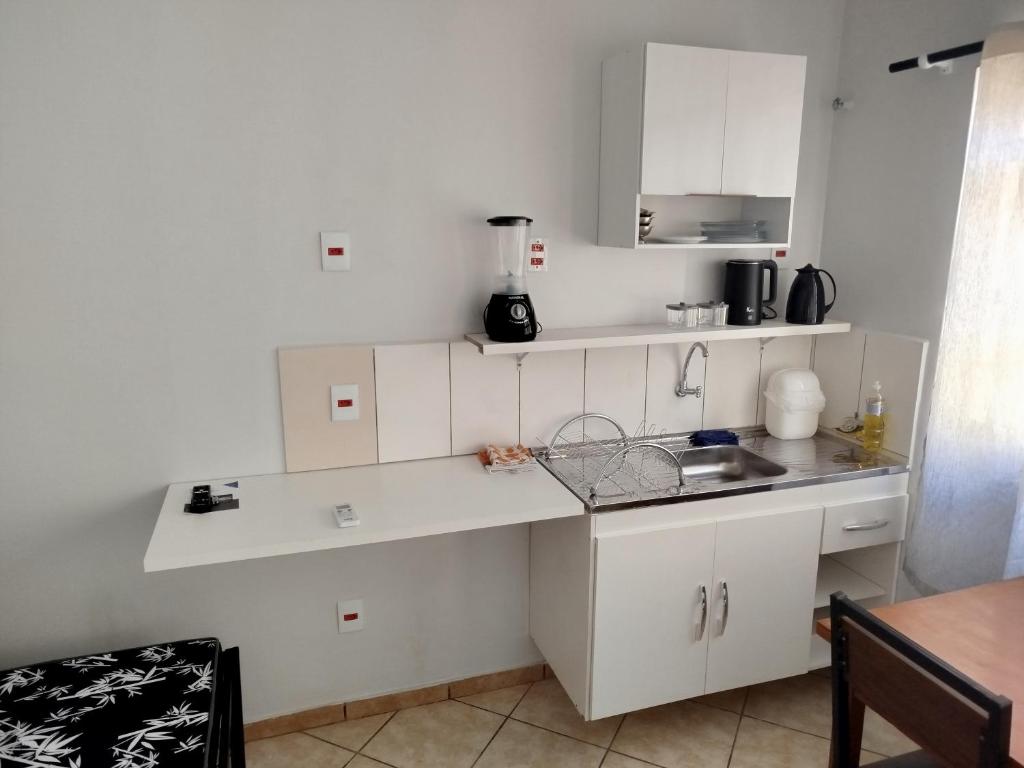 a kitchen with white cabinets and a counter top at Apto 6 ótimo local próximo shopping in Campo Grande