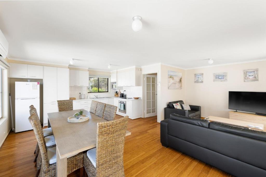 a living room with a table and a black couch at Leura on Ophir in Ventnor
