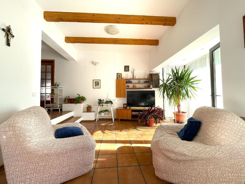 a living room with two chairs and a television at Casa de vis in zona Peles in Sinaia