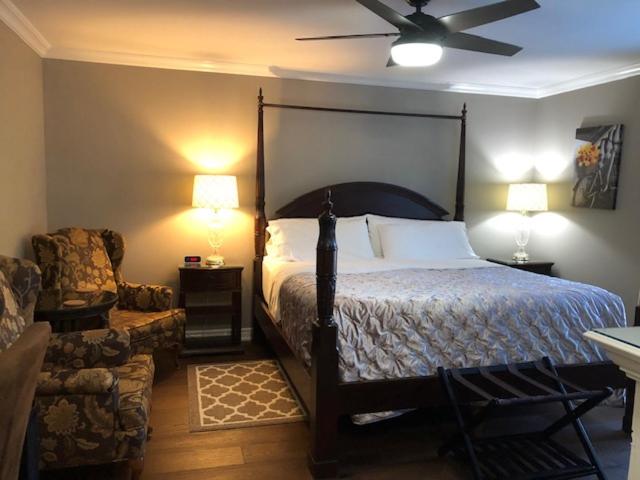 a bedroom with a bed and a chair and two lamps at Casa Blanca Boutique Bed & Breakfast in Niagara-on-the-Lake